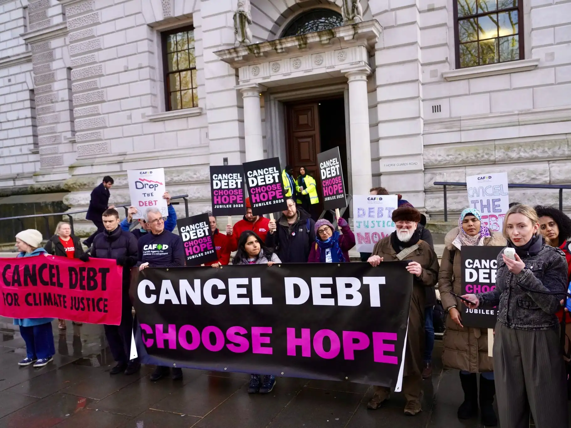 Campaigners stand outside the Treasury calling for debt cancellation