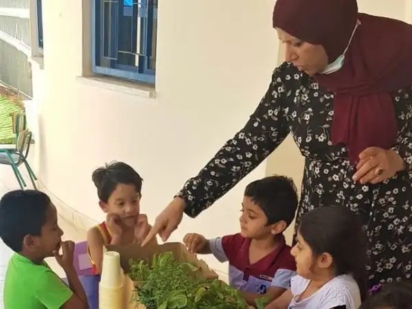 Middle East - Palestinian children with plants in an outdoor classroom